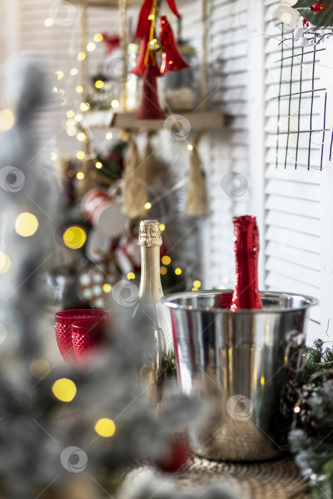 Скачать Бутылки с шампанским и бокалы на столе на фоне рождественских украшений фотосток Ozero