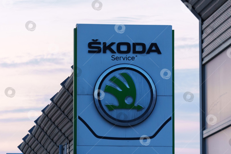 Скачать Тюмень, Россия - 18 марта 2024 года: Реклама автомобиля Skoda с логотипом на боку, демонстрирующая логотип бренда и модель автомобиля. фотосток Ozero