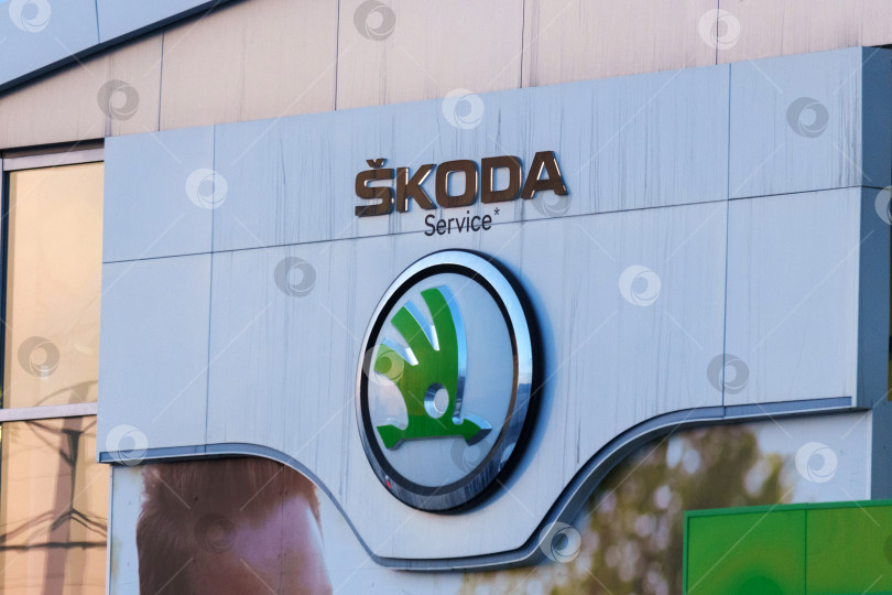 Скачать Тюмень, Россия - 18 марта 2024 года: реклама автомобиля Skoda с логотипом на боку, демонстрирующая логотип бренда и модель автомобиля. фотосток Ozero