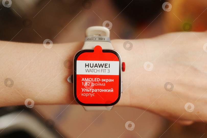 Скачать Тюмень, Россия - 20 июня 2024 года: Часы Huawei Watch 3 подходят для ношения на запястье человека. На циферблате отображается красный экран. фотосток Ozero