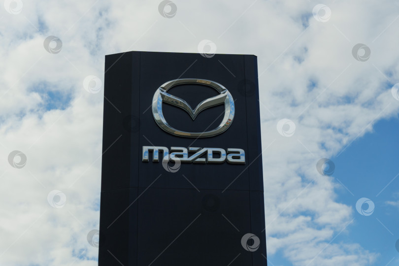 Скачать Тюмень, Россия - 11 августа 2024 года: вывеска дилерского центра Mazda на фоне облачного неба в течение дня фотосток Ozero