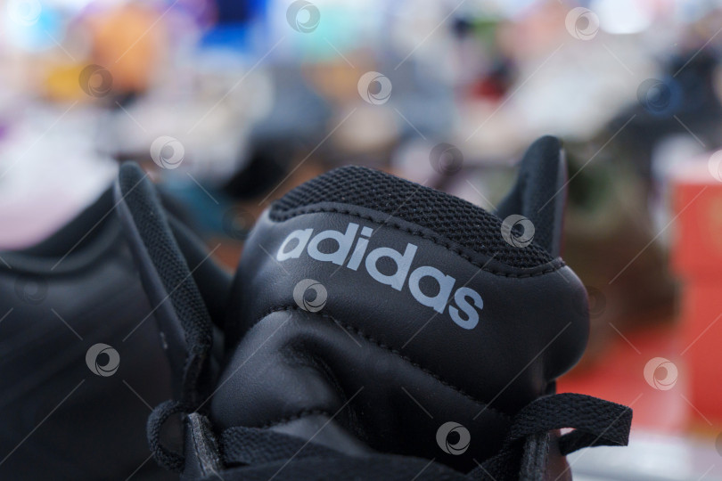 Скачать Тюмень, Россия - 11 августа 2024 года: Спортивная обувь adidas с черными полосками представлена на видном месте в розничной торговле. фотосток Ozero