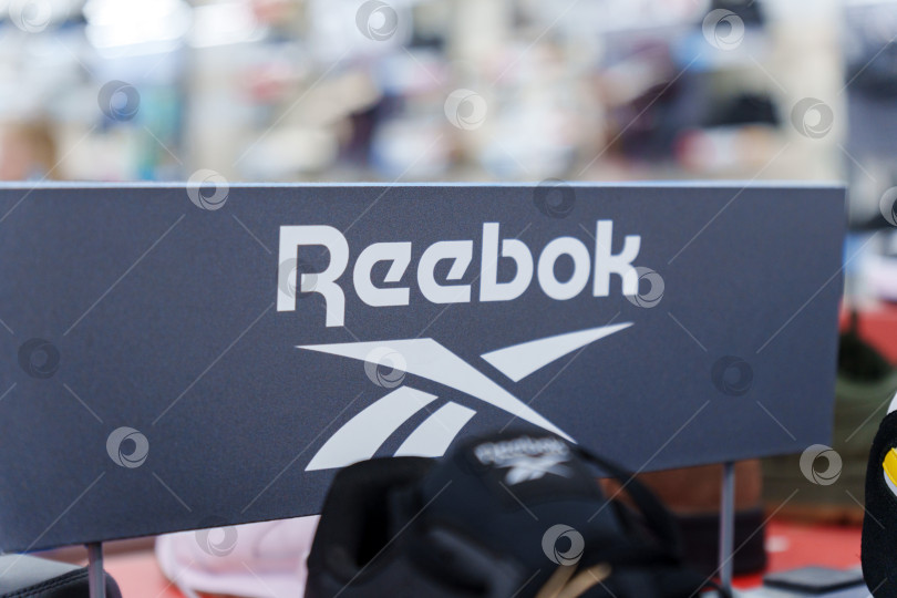 Скачать Тюмень, Россия - 11 августа 2024 года: Выставка спортивной обуви Reebok в розничном магазине, рекламирующем спортивное снаряжение в оживленной торговой среде. фотосток Ozero