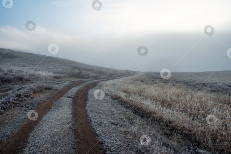 Скачать Утренняя грунтовая дорога через туманное горное плато. фотосток Ozero