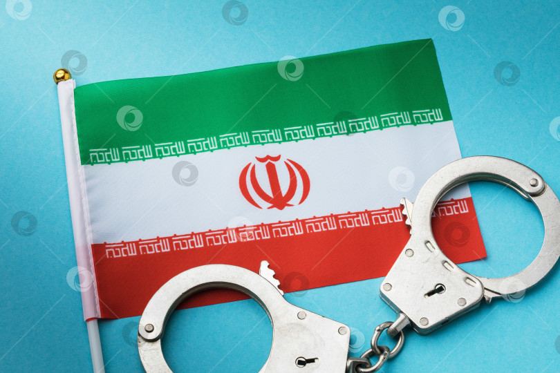 Скачать Флаг Ирана и наручники на цветном фоне, концепция преступности в иранском обществе фотосток Ozero