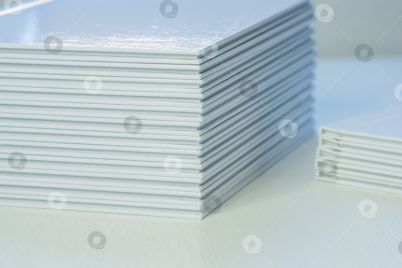 Скачать стопки свежеотпечатанных фотокниг в чистых белых обложках на столе крупным планом фотосток Ozero