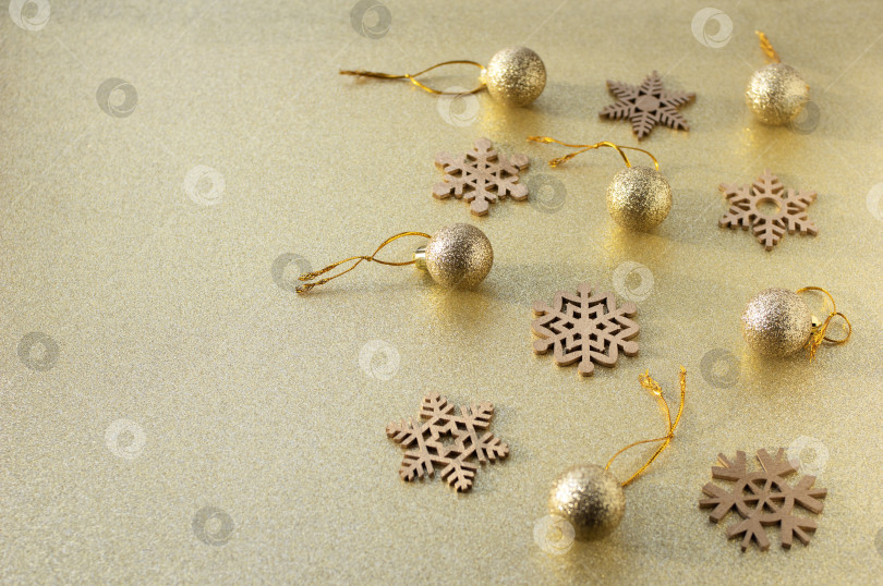 Скачать Золотые рождественские шары и снежинки на блестящем золотом фоне. Пространство для копирования. фотосток Ozero