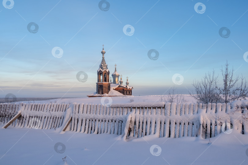 Скачать Деревянный забор занесен снегом, а деревянная церковь фотосток Ozero