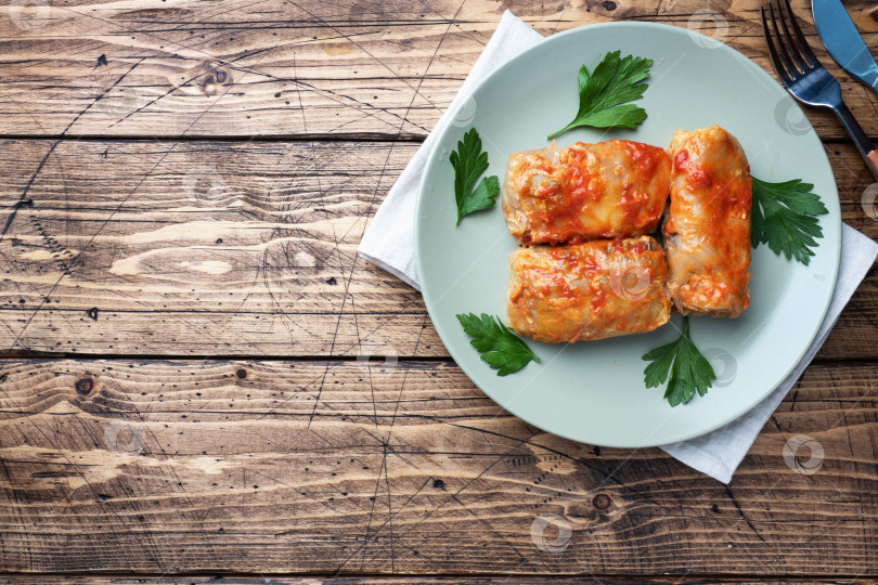 Скачать Голубцы с говядиной, рисом и овощами на тарелке. Голубцы из капустных листьев с мясом. Деревянный фон копирует пространство. фотосток Ozero