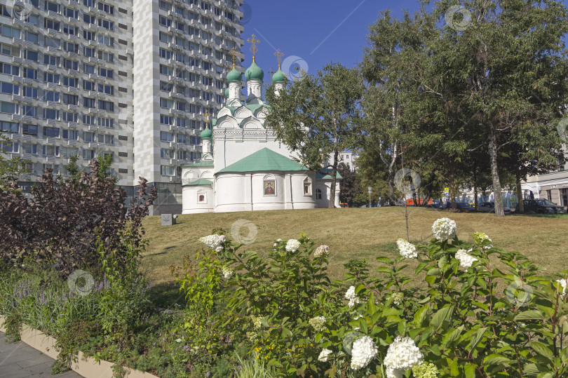 Скачать Старинная православная церковь на фоне современного здания в центре Москвы. фотосток Ozero