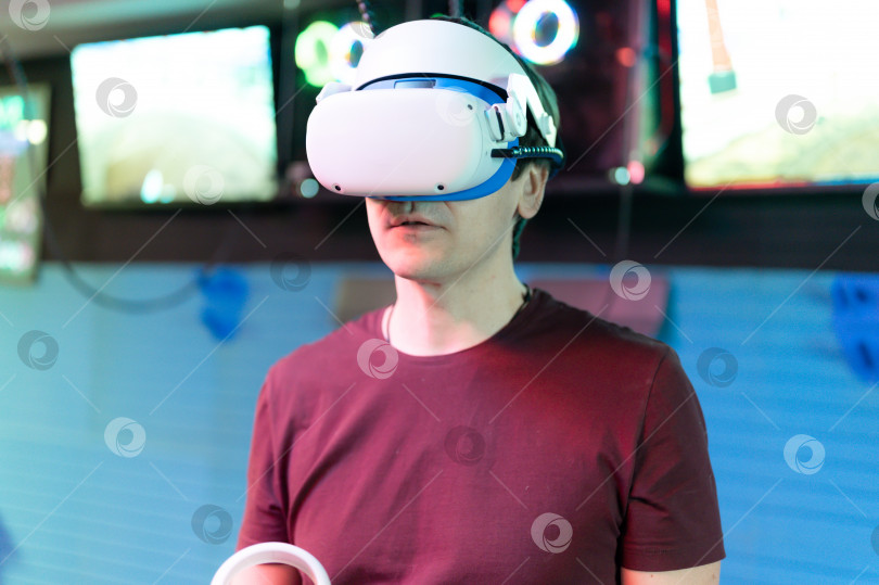 Скачать vr-игра и виртуальная реальность. человек-геймер весело играет на футуристическом симуляторе видеосъемки или исследует учебную игру в 3d-очках и джойстиках в развлекательной виртуальной комнате с инновационной технологией фотосток Ozero