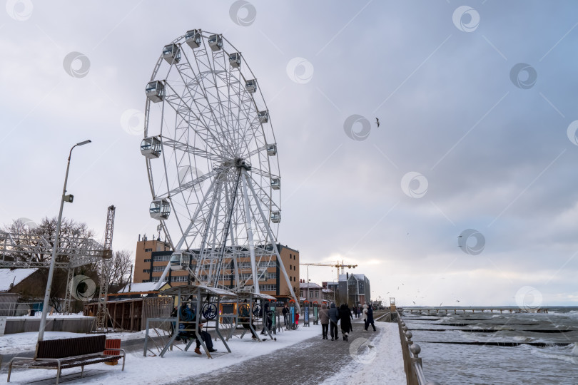 Скачать Пасмурная ветреная погода на морском курорте. Колесо обозрения на набережной. фотосток Ozero