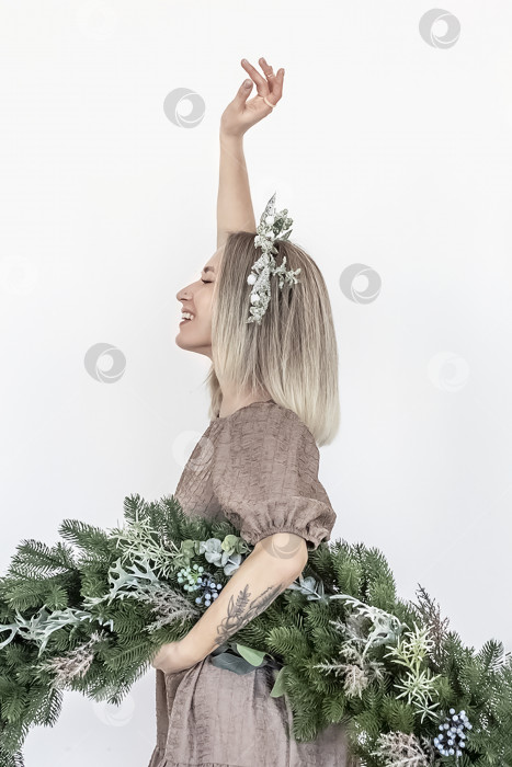 Скачать Молодая женщина со светлыми волосами и рождественским венком. Концепция Нового года, рождественские украшения фотосток Ozero