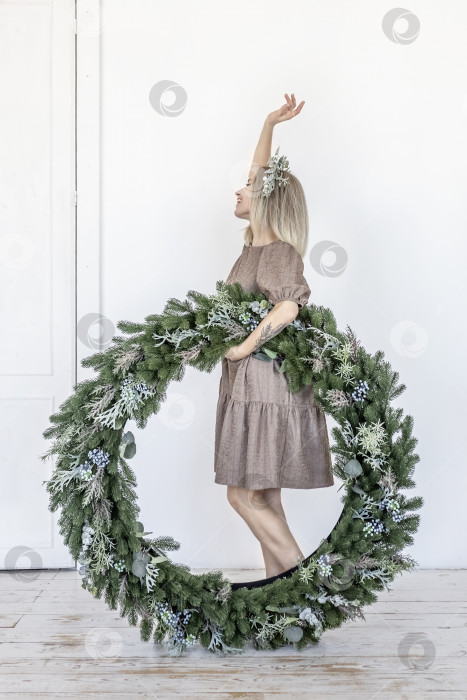 Скачать Молодая женщина со светлыми волосами и рождественским венком. Концепция Нового года, рождественские украшения фотосток Ozero