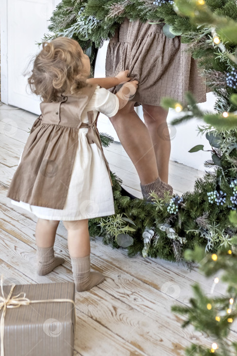 Скачать Молодая женщина со светлыми волосами и маленькая дочь с рождественским венком. Концепция Нового года, рождественские украшения фотосток Ozero
