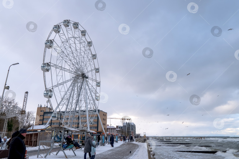 Скачать Пасмурная ветреная погода на морском курорте. Колесо обозрения на набережной. фотосток Ozero