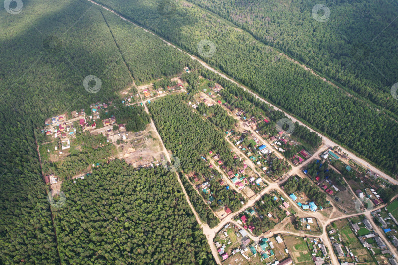 Скачать Вид с высоты птичьего полета на деревню среди хвойного леса. фотосток Ozero