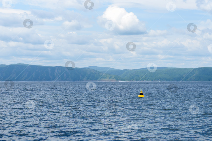 Скачать Желтый и черный буй на воде, знак безопасности на воде фотосток Ozero