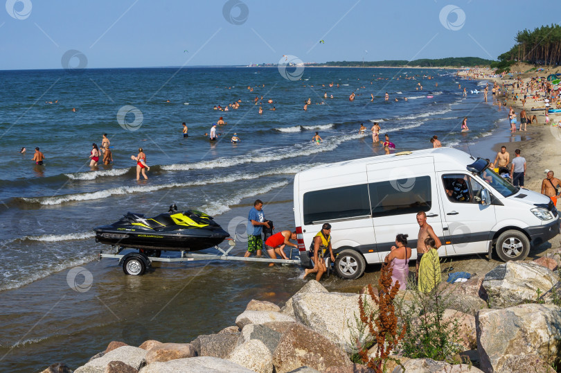 Скачать Гидроцикл загружают в автобус. Развлечения на пляже. фотосток Ozero