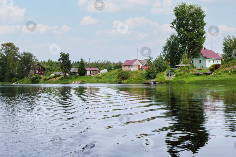 Скачать Деревня и дома на берегу реки. Аккуратная набережная реки. Частная территория у реки. фотосток Ozero