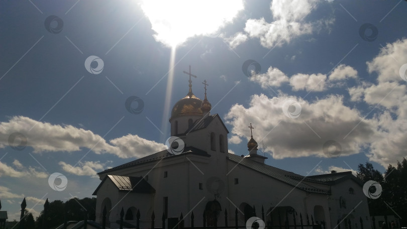 Скачать Православная церковь в городе Колпино, Ленинградская область на фоне облаков и небо. Яркий луч солнца фотосток Ozero