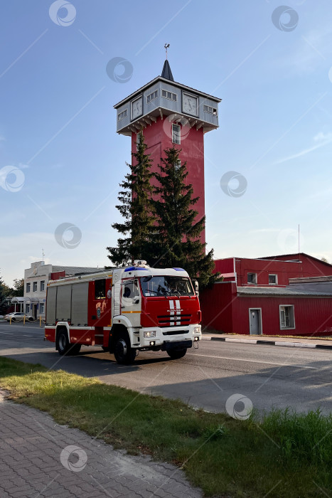 Скачать красная пожарная машина на фоне смотровой пожарной вышки с часами фотосток Ozero