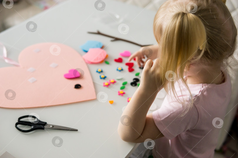 Скачать Девушка-блогер делает поделку из фетра ко Дню святого Валентина в форме сердца. Концепция детского творчества и ручной работы. фотосток Ozero