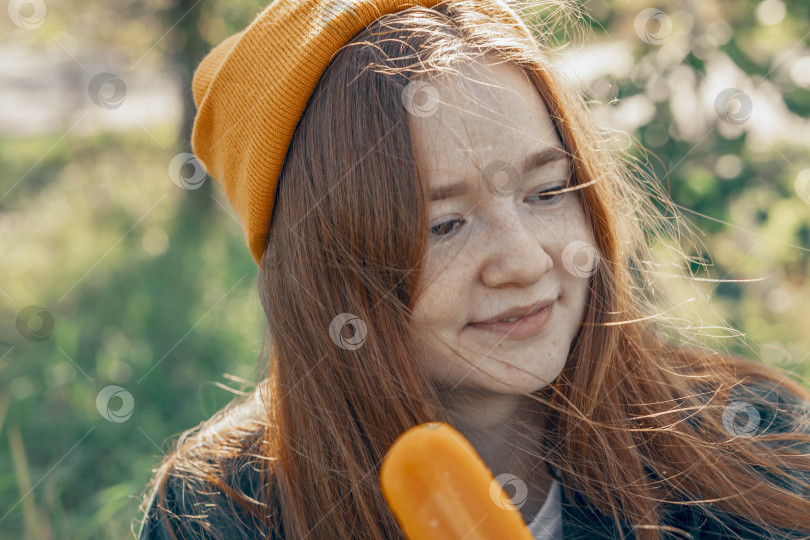 Скачать Frozen Delight - освежающее фруктовое мороженое приносит радость в теплую погоду на улице, осень, женщина в желтой шляпе фотосток Ozero