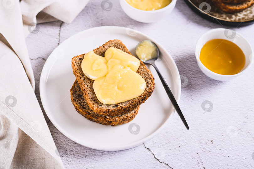 Скачать Вкусные гренки с медовым маслом на тарелке на столе фотосток Ozero