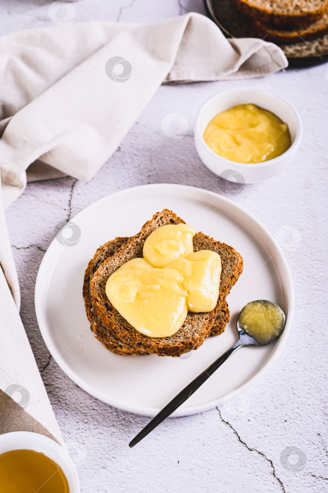 Скачать Вкусные тосты с медовым маслом на тарелке на столе, вид сверху фотосток Ozero