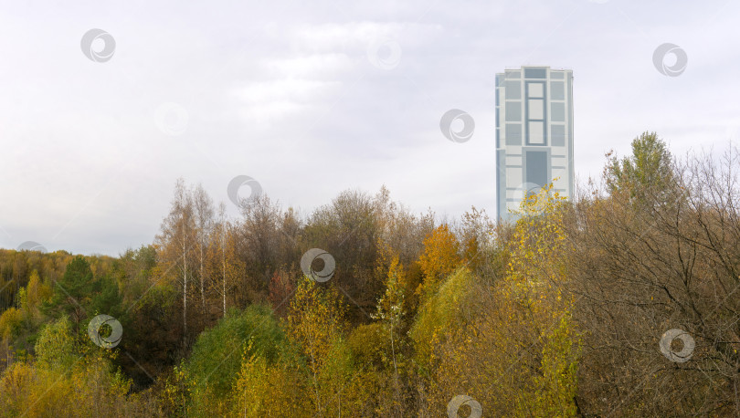 Скачать многоэтажное здание на вершине холма с осенними деревьями фотосток Ozero