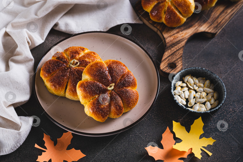 Скачать Осенние булочки в форме тыквы, посыпанные сахаром, на тарелке на столе фотосток Ozero