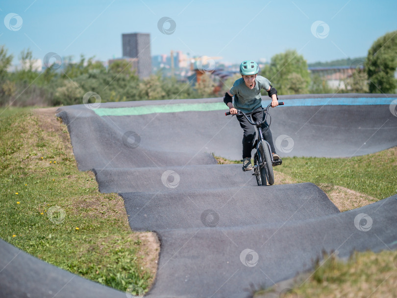 Скачать Памп-трек. Ребенок на велосипеде bmx катается по памп-треку. фотосток Ozero