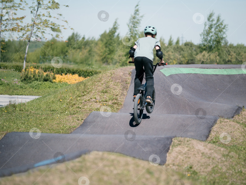 Скачать Памп-трек. Ребенок на велосипеде bmx катается по памп-треку. фотосток Ozero