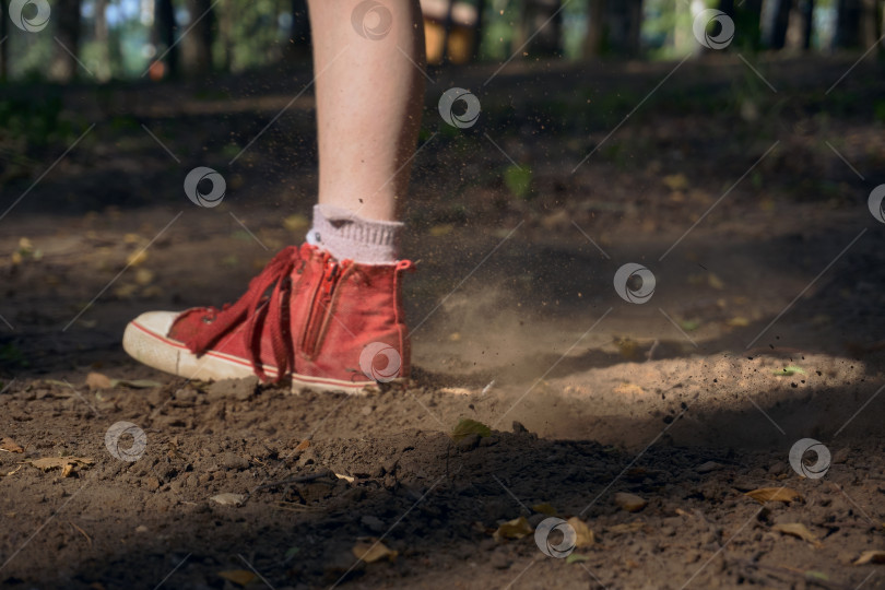 Скачать Мужчина в красных кроссовках бежит по земле в лесопарке. Лес, место для отдыха и занятий спортом. Из-под подошвы летит пыль и грязь крупным планом. Ввод текста с плавным фокусом фотосток Ozero