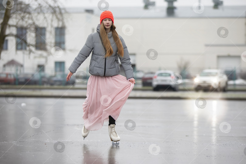 Скачать Девочка-подросток катается на коньках по льду в городе. фотосток Ozero