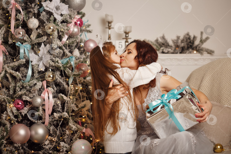 Скачать Дочь дарит своей матери рождественский подарок. фотосток Ozero
