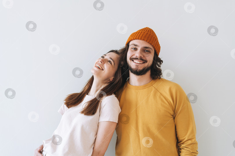Скачать Портрет счастливой пары, молодой семьи, смеющейся на фоне серой стены фотосток Ozero