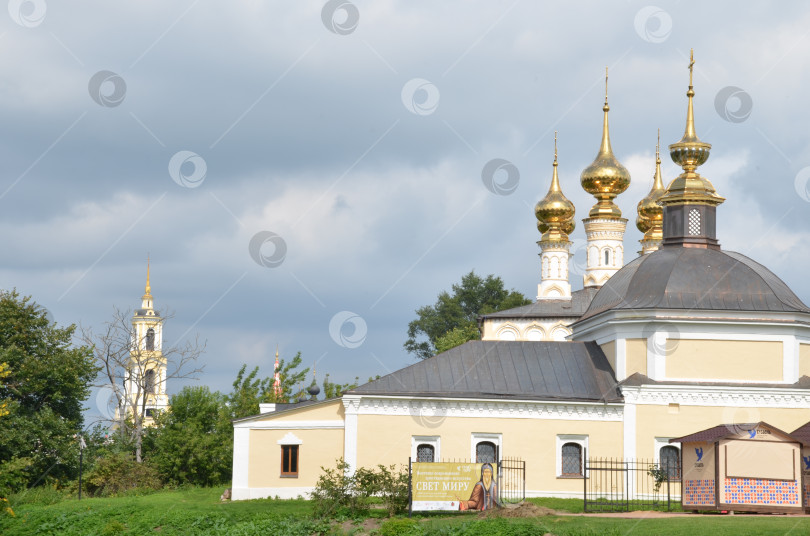 Скачать Церковь Параскевы Пятницы (Пятницкая церковь) и Церковь Входа Господня в Иерусалим (Входо-Иерусалимская церковь) - православные храмы 18 века в городе Суздаль Владимирской области, входящем в Золотое кольцо России, на заднем фоне Преподобенская колокольня Ризоположенского монастыря фотосток Ozero