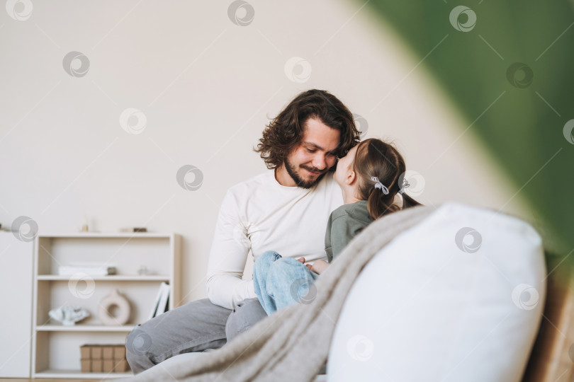 Скачать Молодая счастливая семья с отцом и дочерью на диване в уютном доме, день отца фотосток Ozero