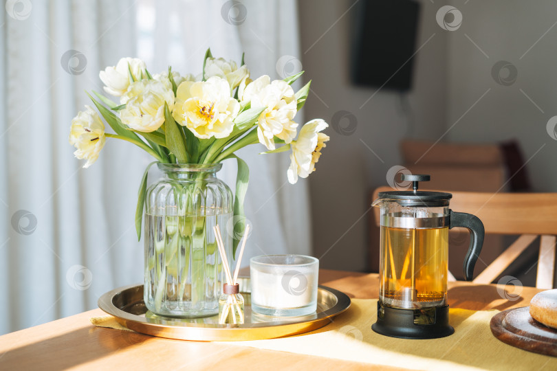 Скачать Красивый букет желтых тюльпанов в вазе на обеденном столе в белой кухне светлый интерьер дома фотосток Ozero