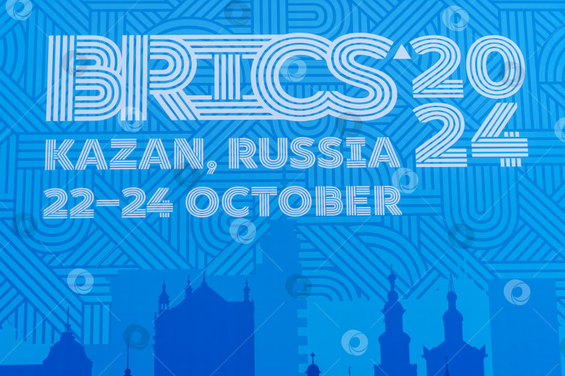 Скачать Надпись BRICS 2024, Казань, Россия, 22-24 октября на синем фоне. Официальный синий логотип саммита БРИКС 2024 в Казани. Россия, Казань, 26 октября 2024 г. фотосток Ozero