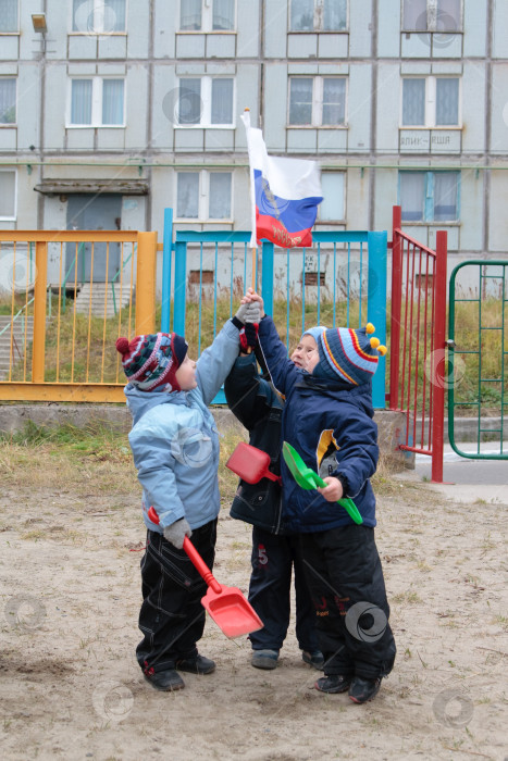 Скачать Трое маленьких детей держат в руках Российский флаг фотосток Ozero