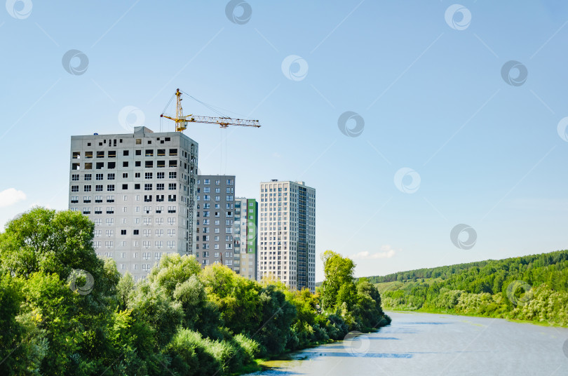 Скачать На берегах реки строятся новые многоквартирные дома. Башенный кран во время строительства фотосток Ozero