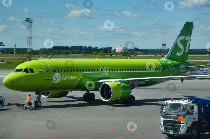 Скачать Зеленый самолет S7 Airlines на фоне голубого неба. Пассажирский авиалайнер Boeing 737-800 находится на взлетно-посадочной полосе фотосток Ozero