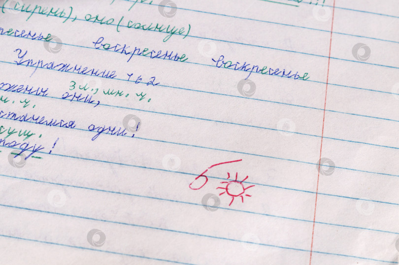 Скачать Саратов, Россия - 2 ноября 2024 года. Школьная работа - В тетради по русскому языку поставлена оценка пять и солнышко фотосток Ozero