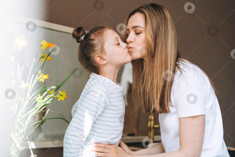 Скачать Молодая женщина-мать с длинными волосами и маленькой дочерью-подростком в пижаме развлекаются утром дома фотосток Ozero