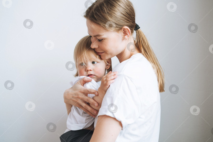 Скачать Портрет молодой женщины-матери, целующей маленькую девочку-дочку на руках дома фотосток Ozero