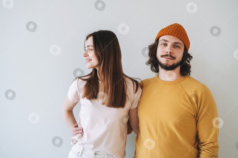 Скачать Портрет улыбающейся пары молодых семейных хипстеров на фоне серой стены фотосток Ozero