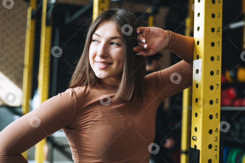 Скачать Портрет молодой брюнетки в спортивной одежде для активного отдыха в тренажерном зале фитнес-клуба фотосток Ozero
